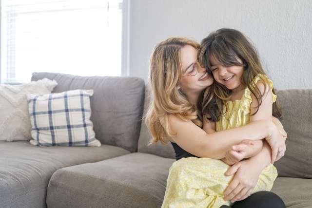 妈妈克拉丽莎·霍普拥抱着她微笑的女儿瑞莉·奥苏娜.